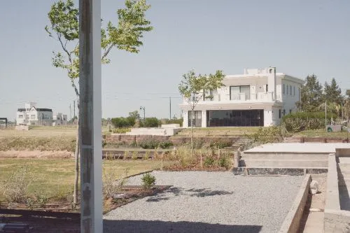 Canteros recién plantados con vista a la casa vecina y la laguna